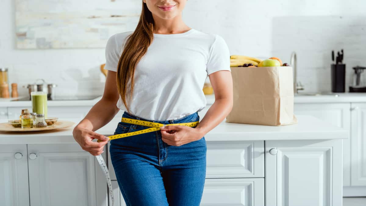 A woman measuring her 26 inch waist
