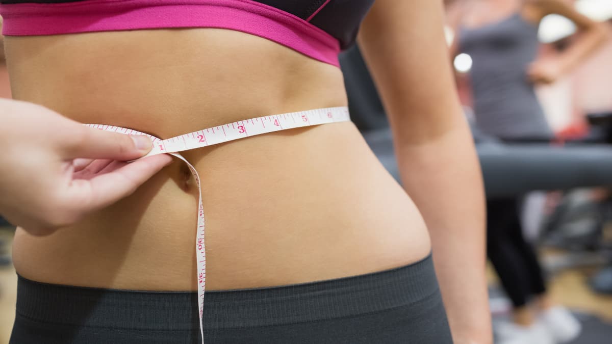 A woman getting her 31 inch waist measured