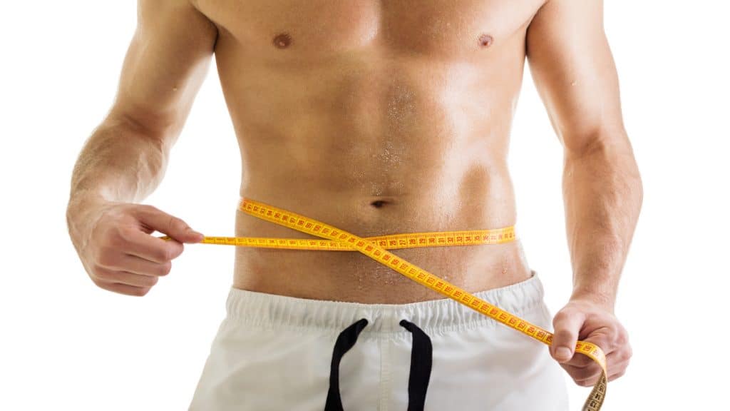 A man with a 32 inch waist measuring his waistline