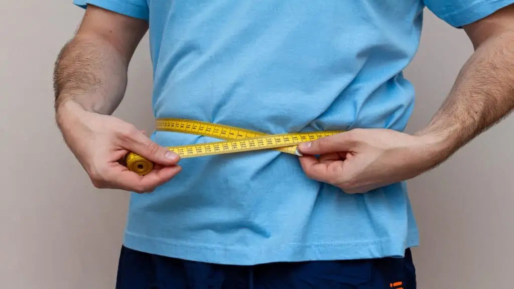 A man measuring his 34 in waist