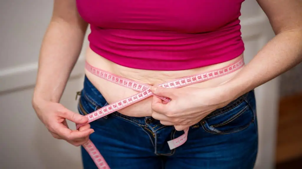 A female measuring her 35 inch waist