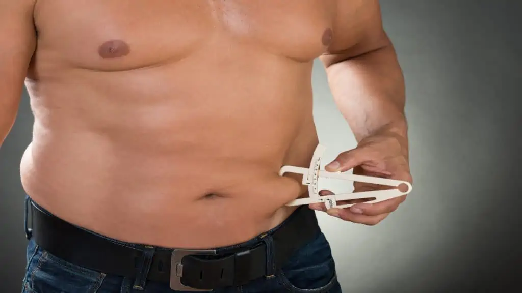 A man with a 38 in waist measuring his body fat