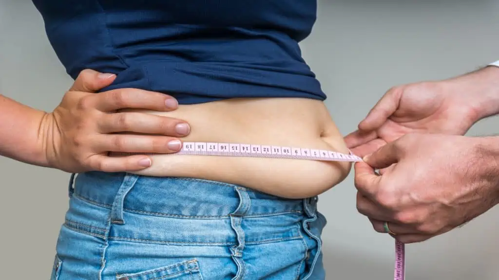 A woman getting her 38 inch waist measured