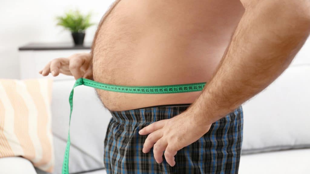 A man measuring his large 39 inch waistline