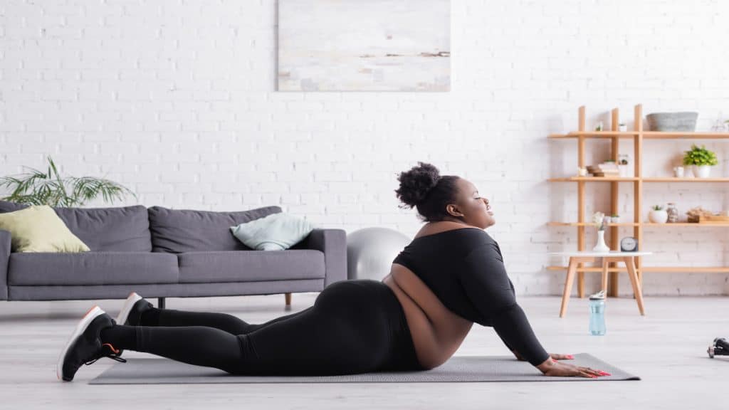 A woman with a 47 inch waistline working out in her living room