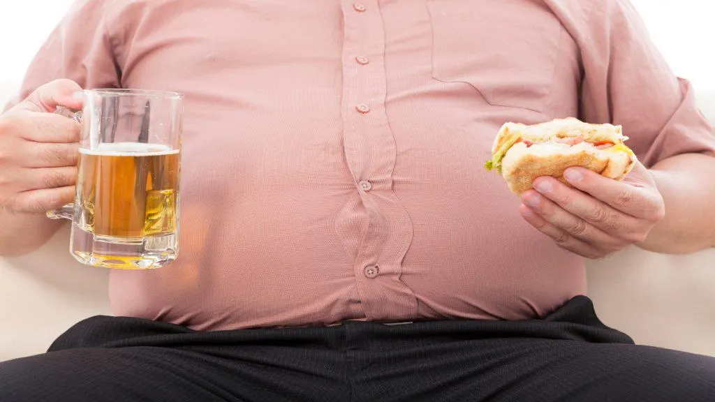 A man with a 48 in waist holding a burger