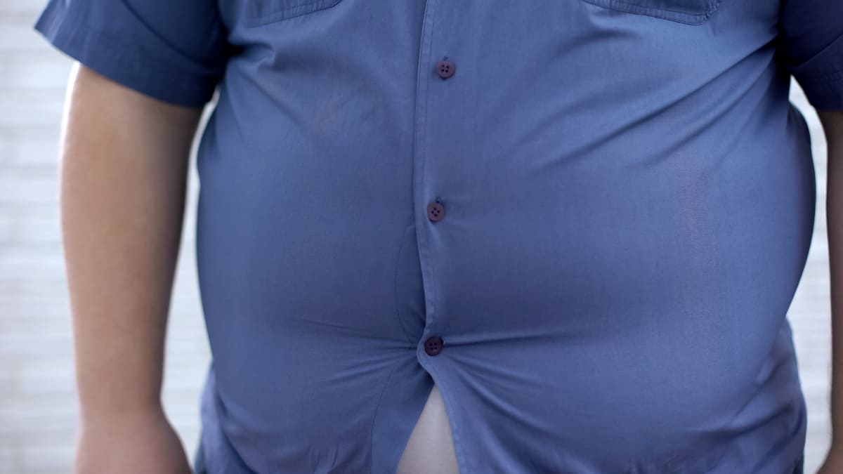 A man's 62 inch waist bursting through his shirt