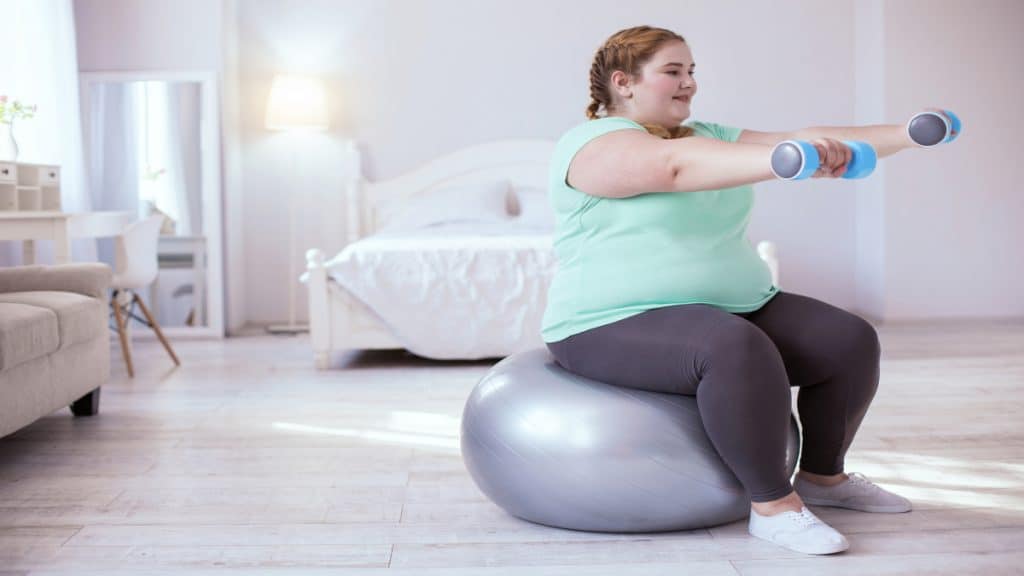 An obese woman with a 64 inch waist doing some exercises