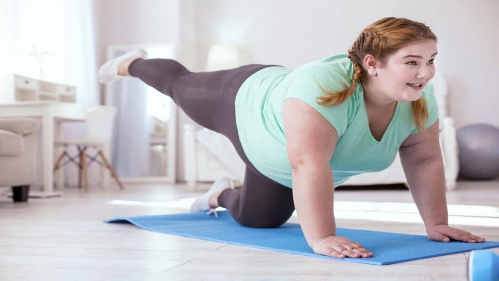 An obese woman with a 65 in waist doing some exercise