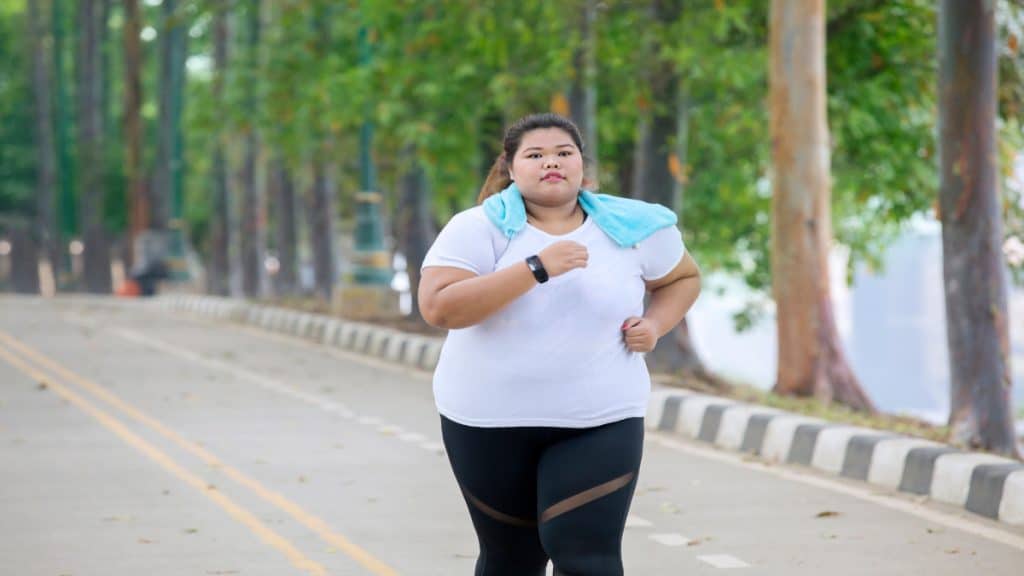 An obese woman with a 75 inch waist jogging outside