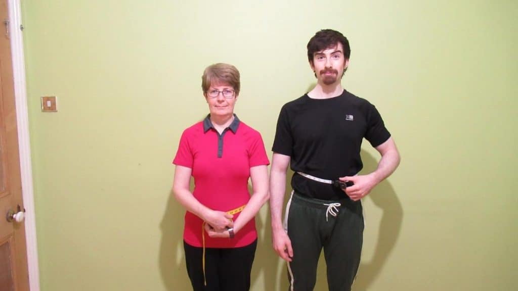 A man and a woman demonstrating the average waist size by height