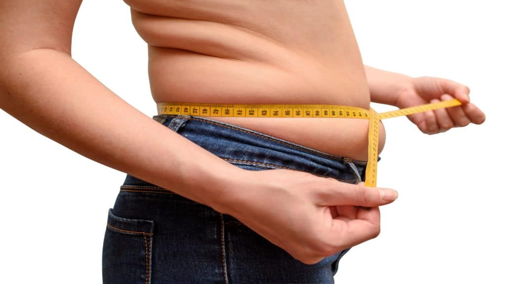 A woman measuring her fat 35 inch waist