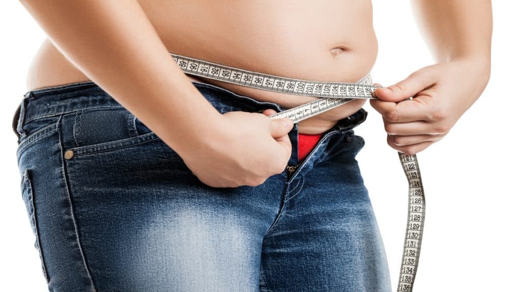 A fat woman measuring her big 37 inch waist