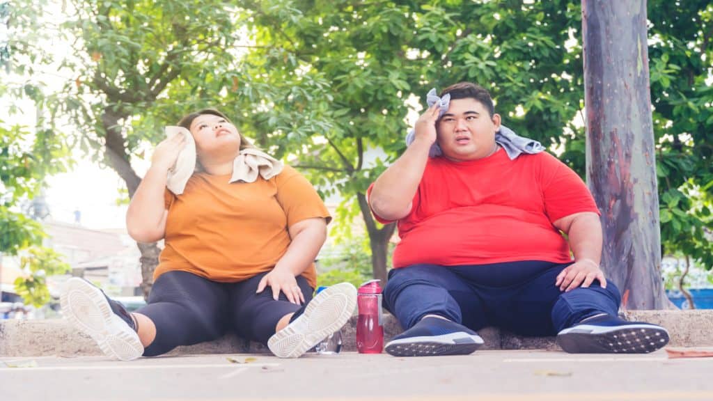 An obese couple sat outside after exercise