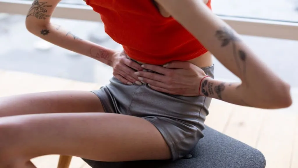 A skinny woman clutching her seventeen inch waist