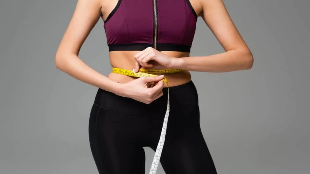 A woman demonstrating what a 29 inch waist looks like