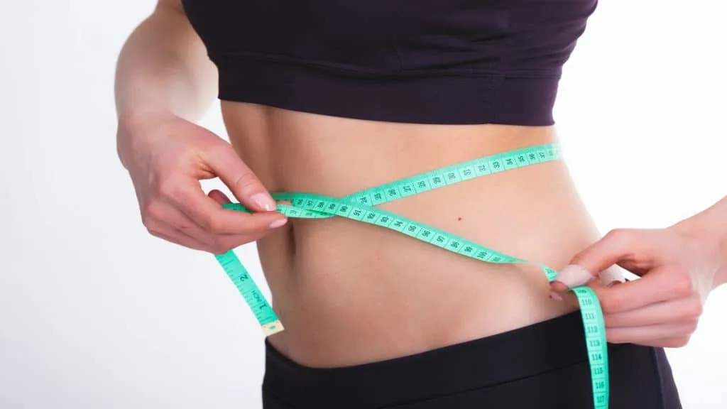 A woman demonstrating what a 30 inch waist looks like