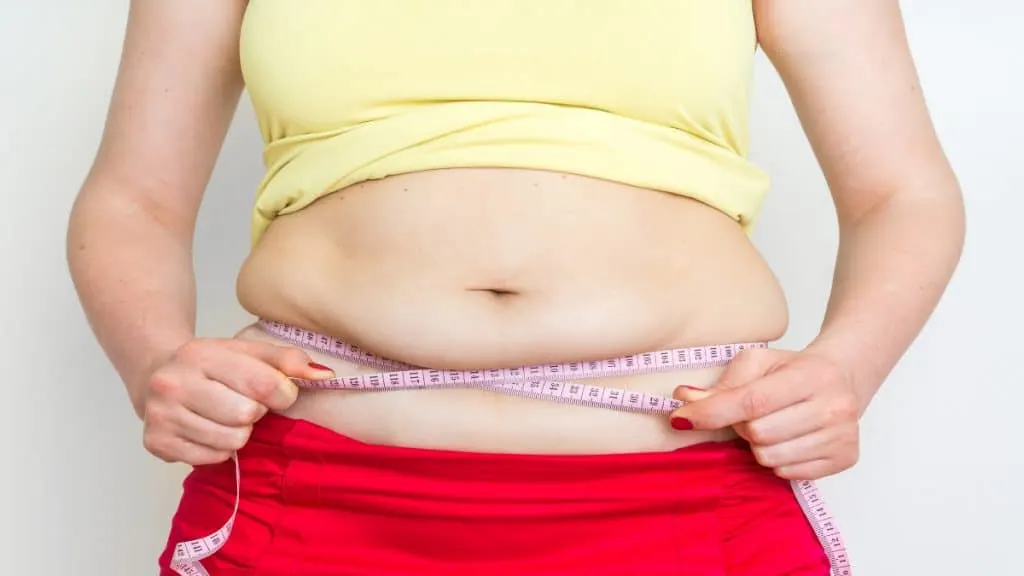 A woman demonstrating what a 36 inch waist looks like