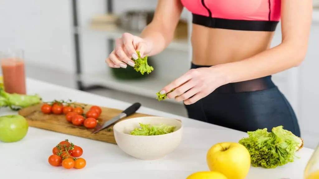 A slim woman making a salad