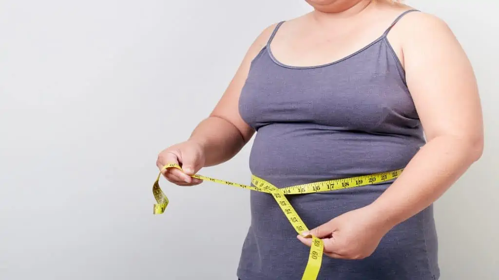 A woman demonstrating what her 40 inch waist looks like