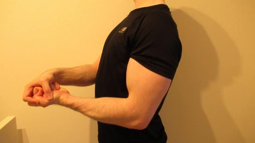 A man showing that he has small triceps and big biceps
