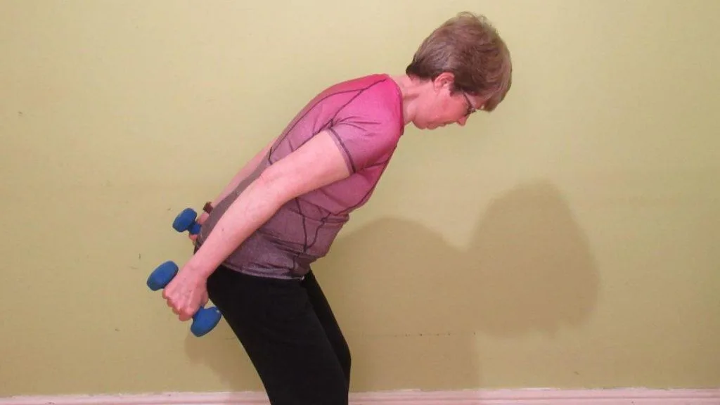 A woman doing a tricep kickback