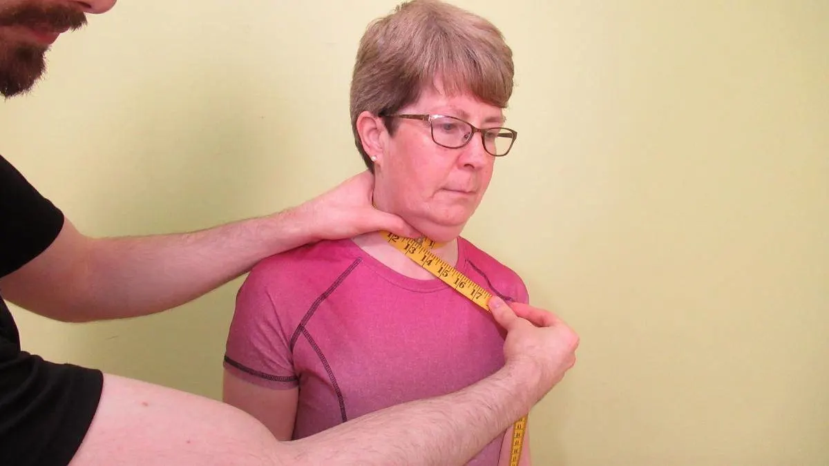 A woman getting her 14 inch neck measured