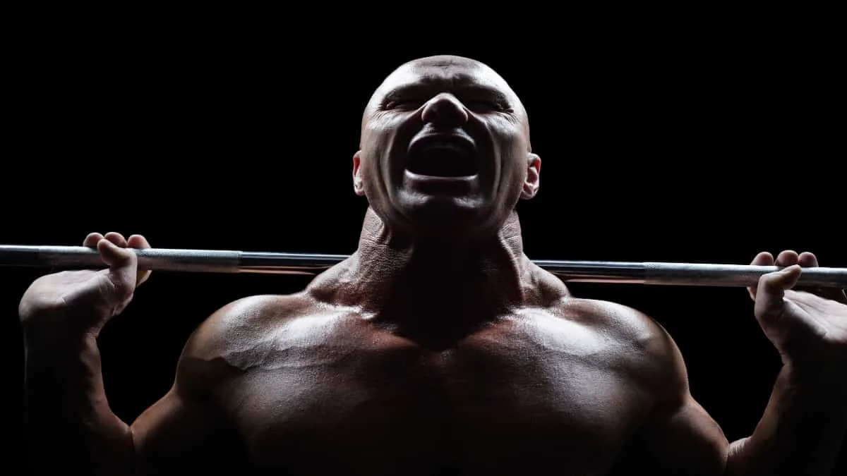 A bodybuilder flexing his 22 inch neck muscles