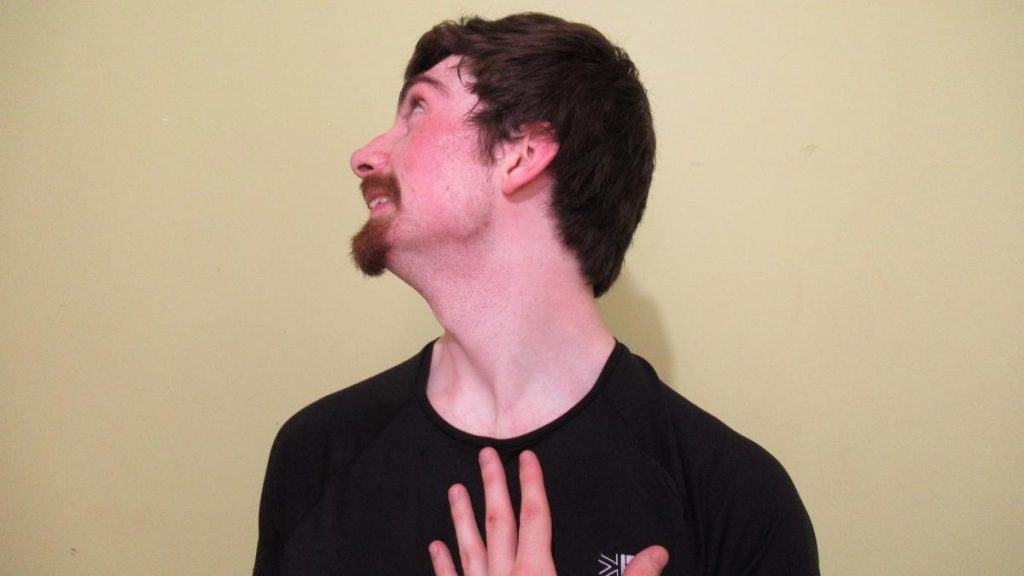 A man showing that his 15 inch neck is big