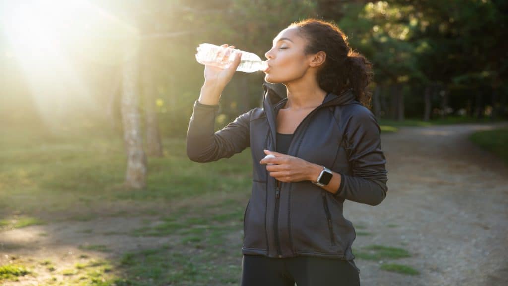 A sporty woman drinking water