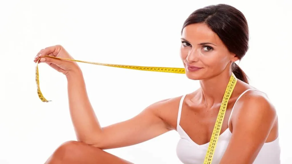 An athletic woman holding a tape measure