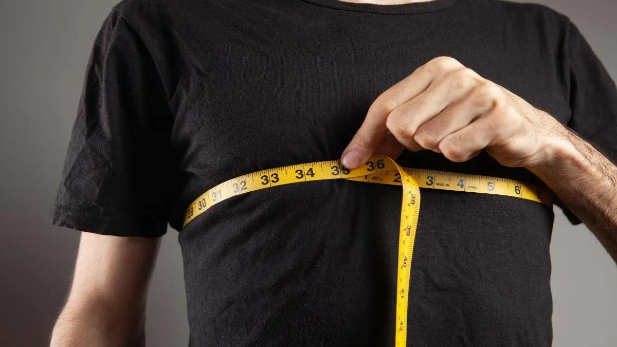 A man measuring his 34 inch chest