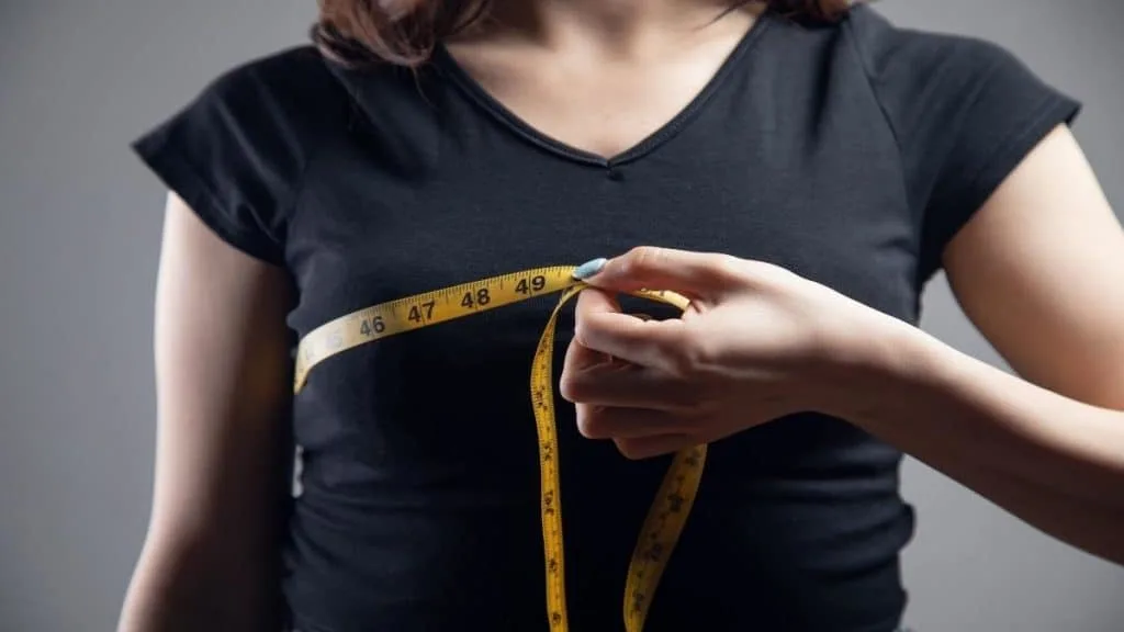 A woman measuring her 35 inch chest