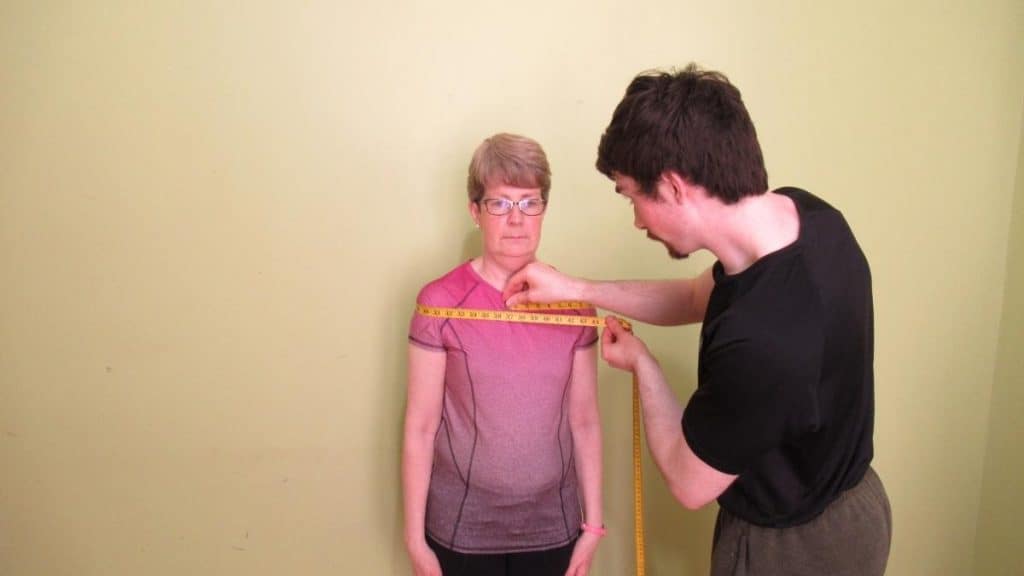 A woman getting her 40 inch shoulders measured