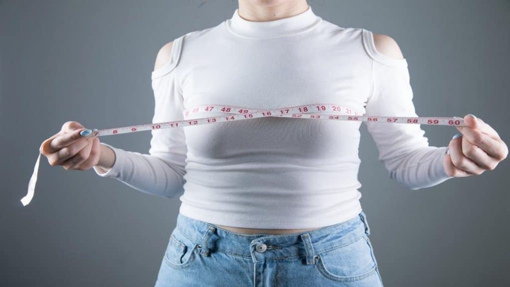 A woman measuring her 42 inch chest
