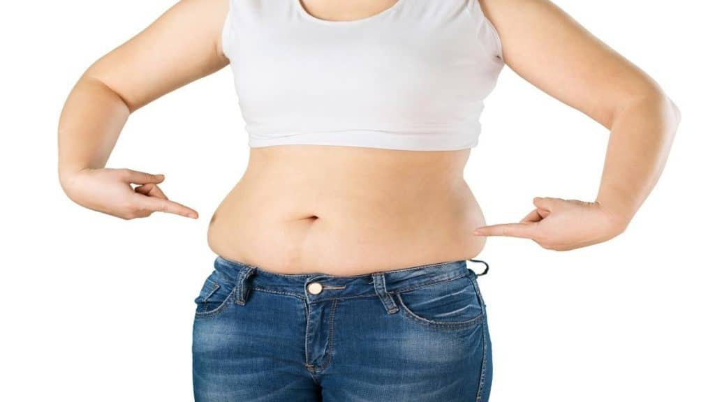 An obese woman pointing at her 49 inch hips