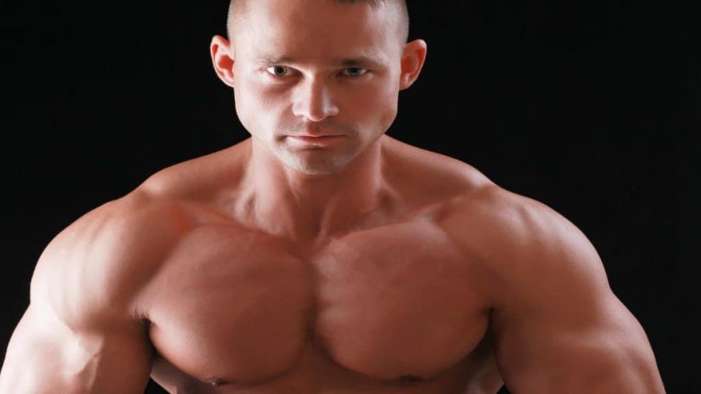 A bodybuilder flexing his 51 inch shoulders