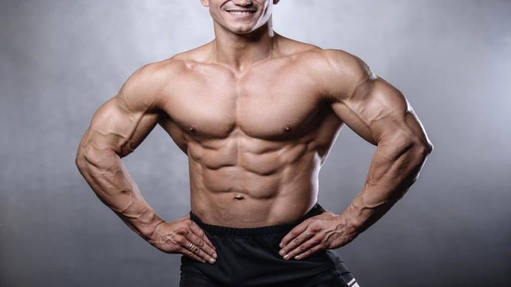 A bodybuilder showing his big 55 inch shoulders