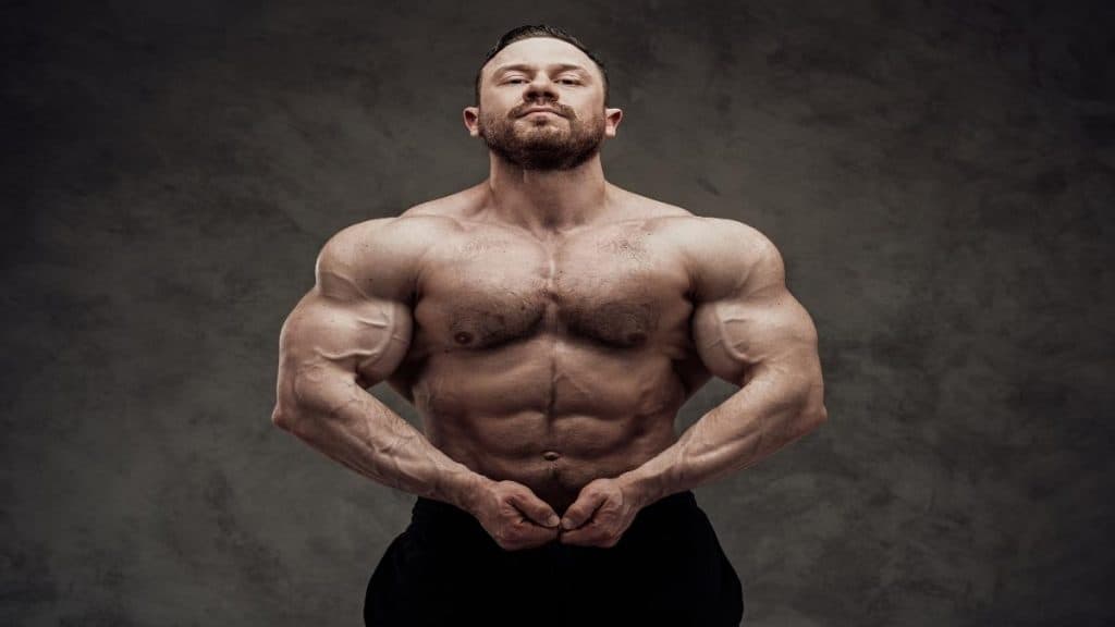 A bodybuilder flexing his 57 inch shoulders
