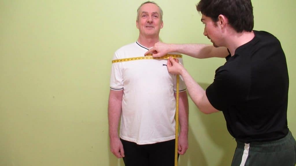 A man showing that he has a very average shoulder circumference for males of his age