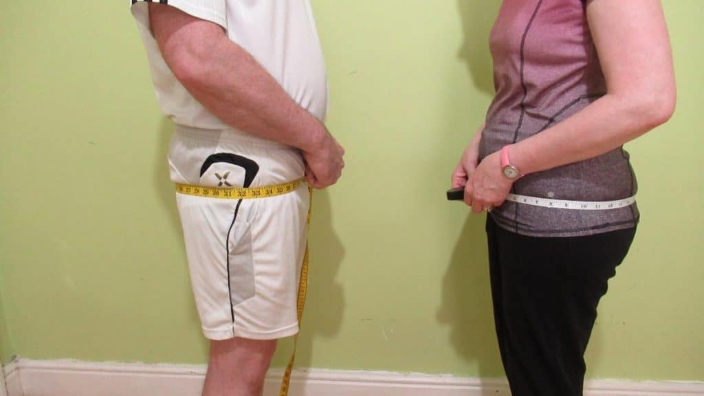 A male and a female showing their hip girth measurement