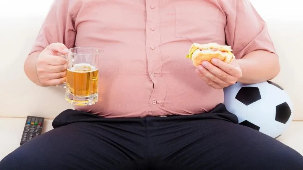 An obese man eating a burger