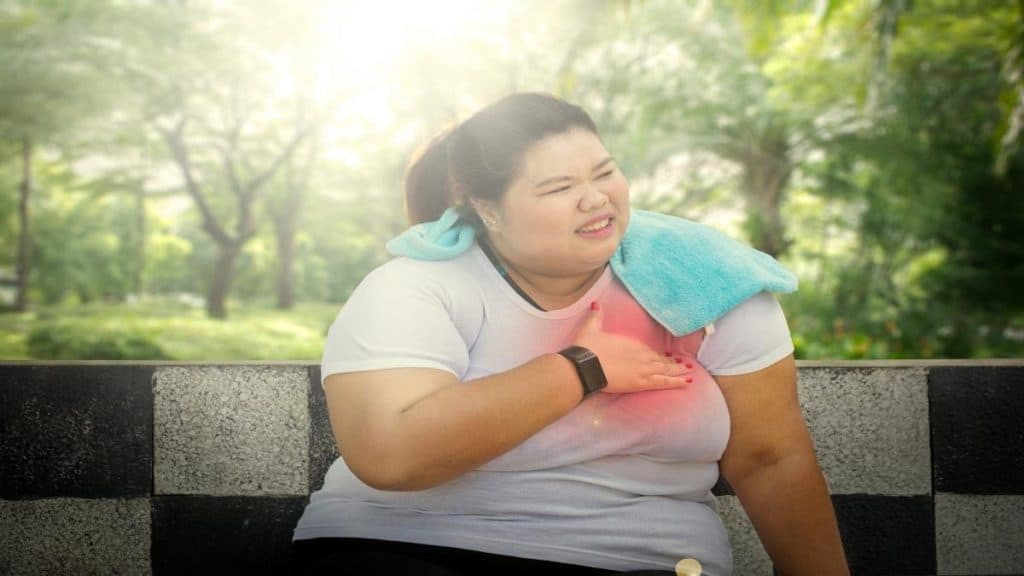 An obese woman holding her chest