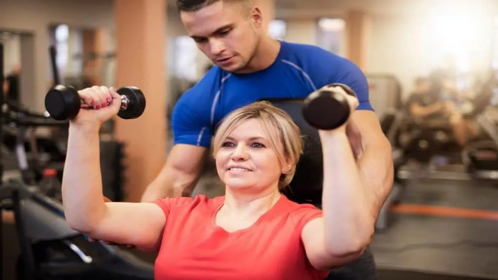 A woman doing a shoulder press exercise at the gym