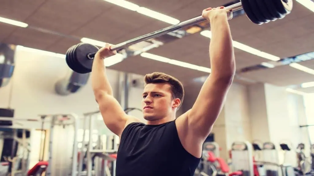 A man doing a shoulder press at the gym