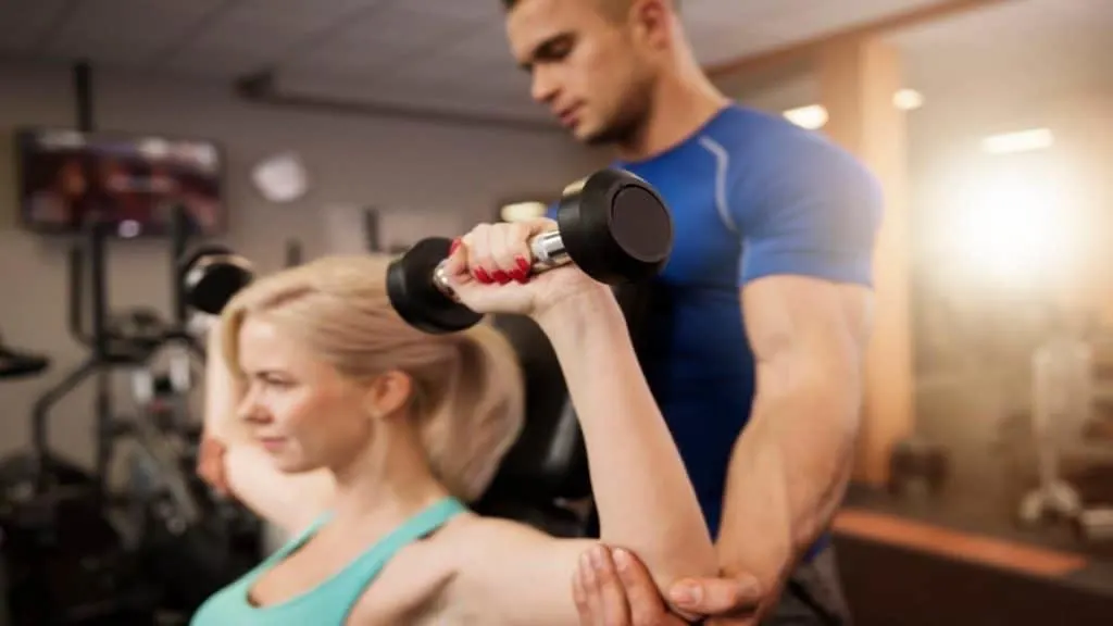 A woman doing a shoulder press at the gym