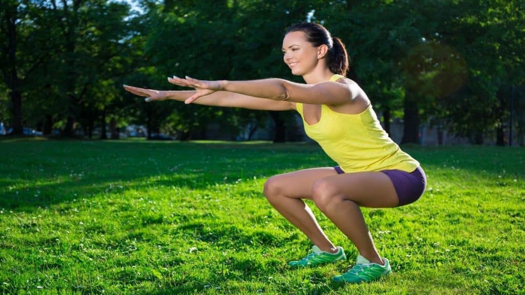 A woman doing squats in the park