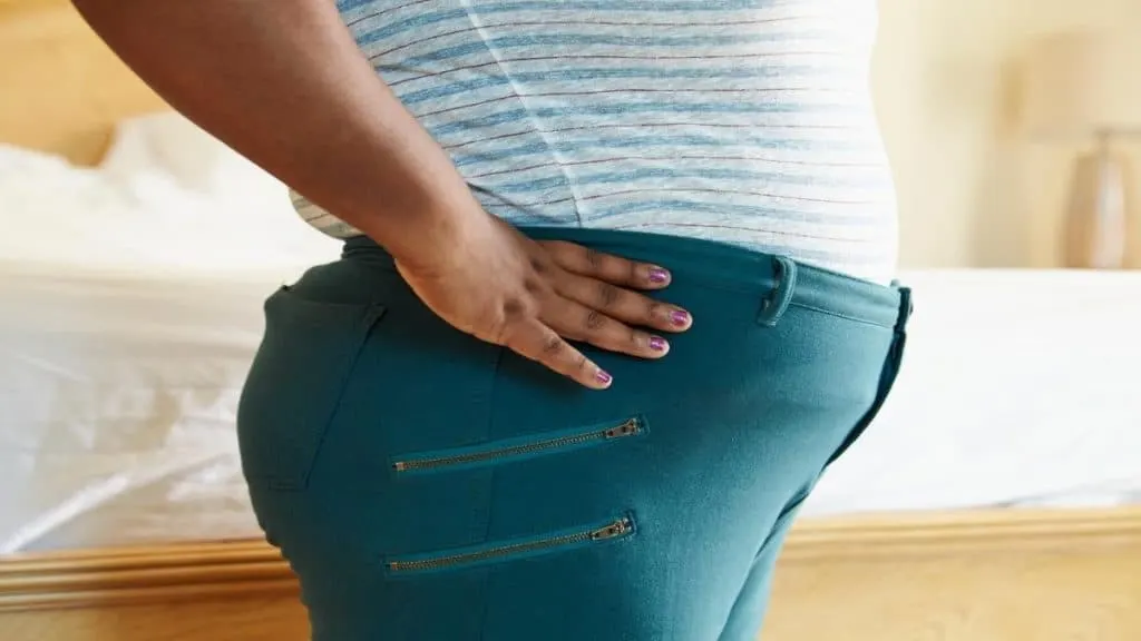 An obese woman showing that she has a 100 inch booty