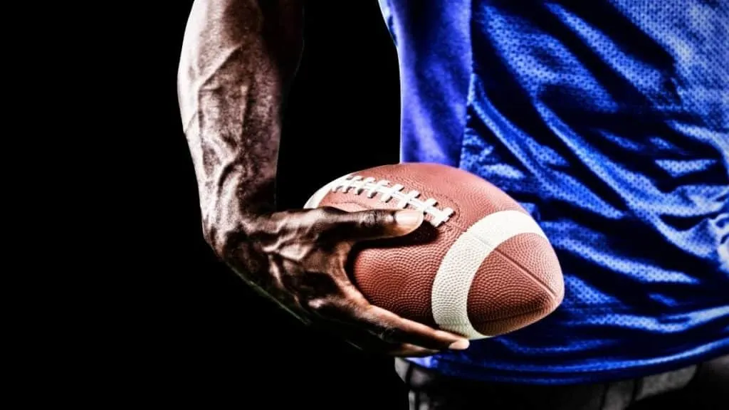 A man with 11 inch wrists holding a football