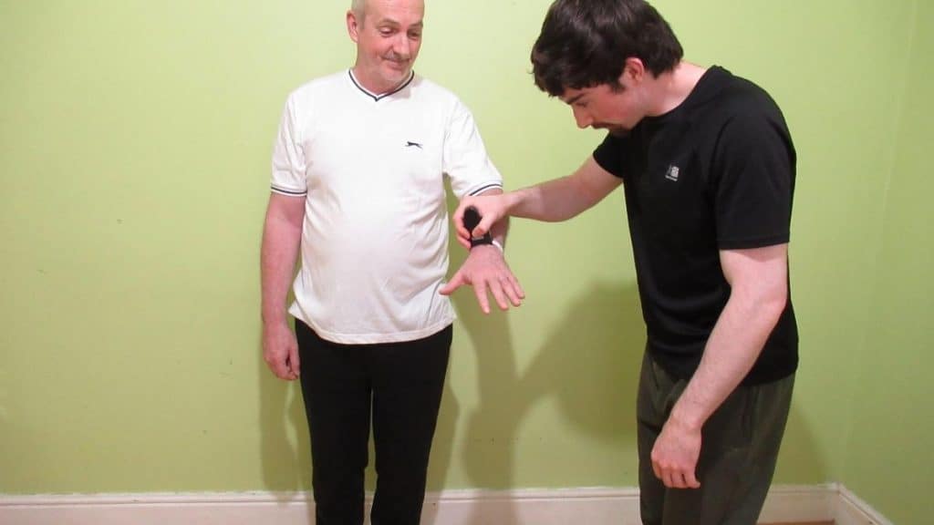 A man getting his wrist measured to see if he has an average male wrist size
